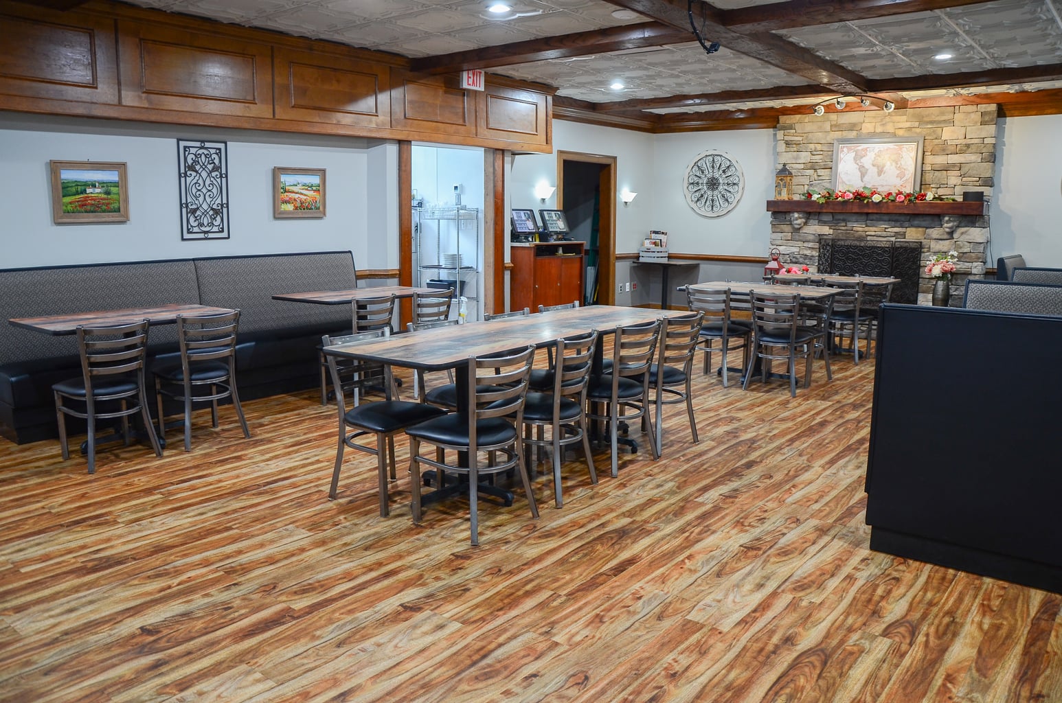 Larger event space at Ledo Pizza Lynchburg with dining tables, booth seating, and stone fireplace