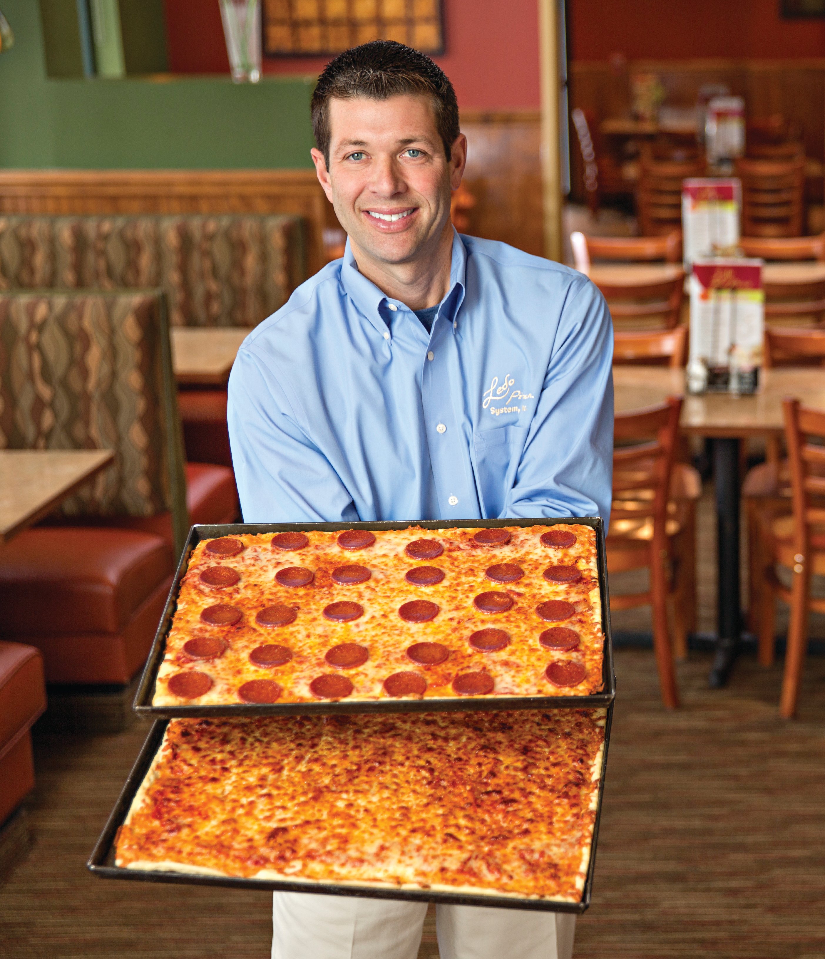 Jamie Beall holding pepperoni and cheese pizzas